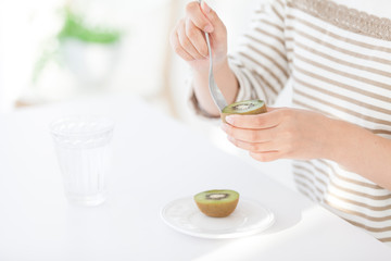 キウイフルーツを食べる女性の手元