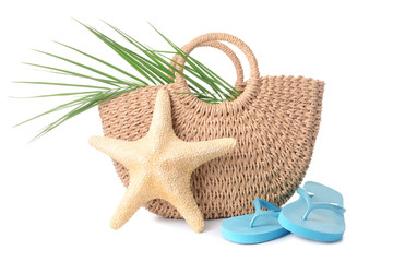 Beach bag, flip-flops and starfish on white background