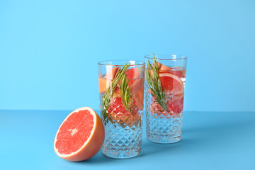 Glasses of infused water on color background