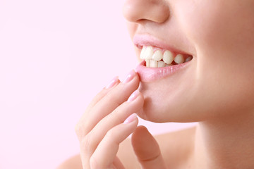 Young woman with beautiful lips on color background, closeup