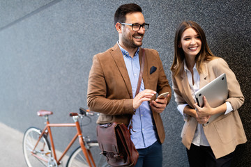 Fototapeta premium Happy business colleagues talking and walking in the city outdoor