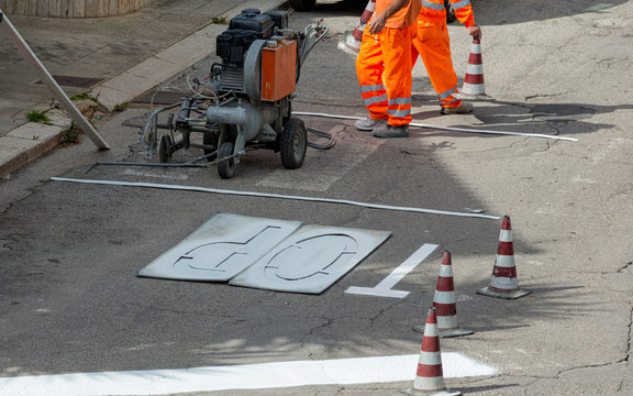 machine and workers at road construction use for road and traffic sign painting