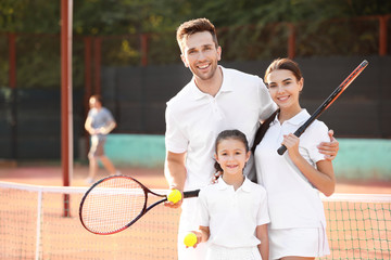 Happy family on tennis court
