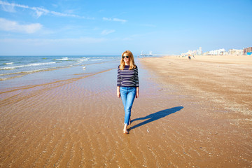 Smiling woman walking on the seaside