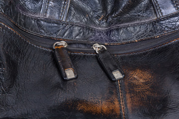 Fragment of zipper with leather pullers on old leather handbag