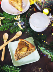 Top view Christmas dessert table: apple pie, hot capucino with tree branches and toys. New year