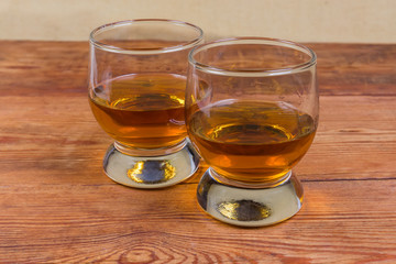 Two portions of brandy in brandy bowls on rustic table