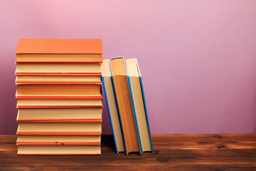  pile of old books, panorma, good copy space  on pink background
