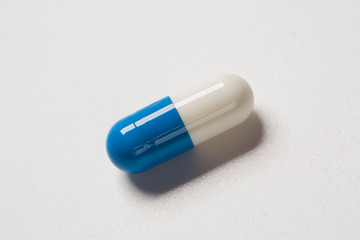 Single capsule pill isolated on white background