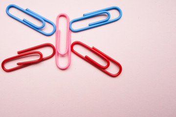 multicolored paper clips on a pink background in the form of a butterfly. Concept Back to School.