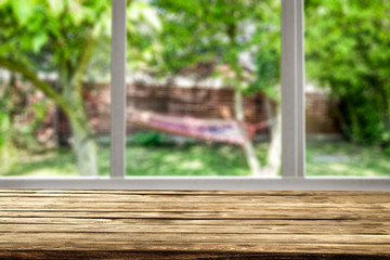 Naklejka premium Wooden desk of free space and window background 