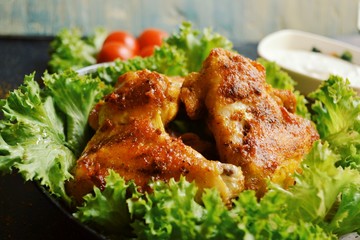 Juicy delicious fried chicken wings. Grilled meat with lettuce.