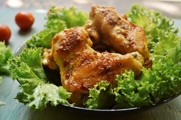 Juicy delicious fried chicken wings. Grilled meat with lettuce.