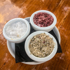 3 different types os salt on small white containers.