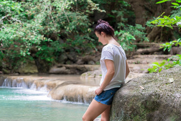 young cute hipster girl travelling at beautiful Erawan waterfall mountains  green forest hiking views at Kanchanaburi, Thailand. guiding  idea for female backpacker woman women backpacking
