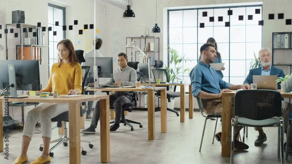 Aufkleber in the stylish open space office: diverse group of enthusiastic business marketing professionals use