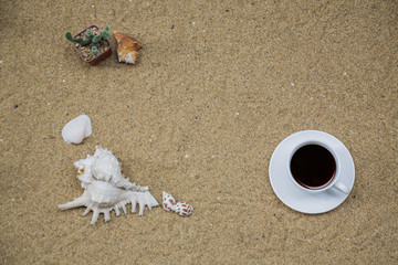 summer accessories Coffee with note paper and seashell on the beach