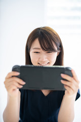 Fototapeta premium 携帯ゲーム機で遊ぶ女性