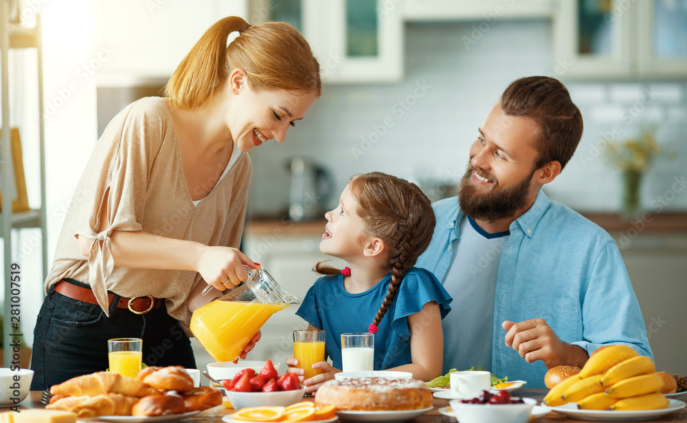 Wall mural family mother father and child daughter have breakfast in kitchen in morning.