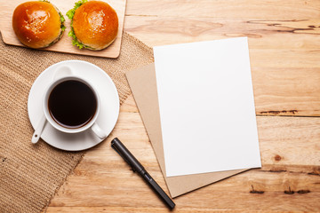 Coffee with homemade bread, note pad on wooden table