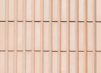 Orange rectangular tiles wall with rough surface as background