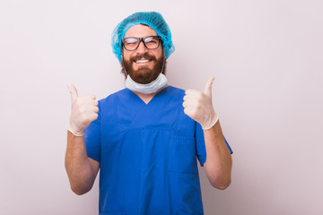 Photo of happy smiling doctor showing thumbs up over white background