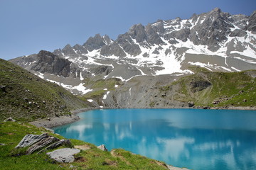 Sainte Anne lake located above Ceillac village after two hours hike, with reflections of mountain range covered with snow, Queyras Regional Natural Park, Southern Alps, France