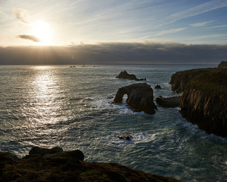 Sunset at Land's End over Enys Dodman rock arch, Longships Lighthouse, Cornwall
