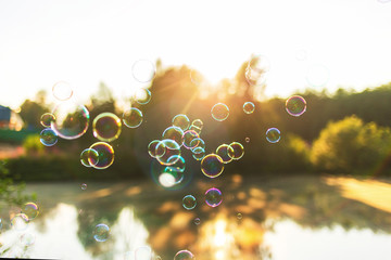 beautiful background with soap bubbles at sunset lake