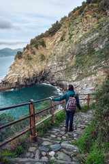 Fototapeta na wymiar Ligurian coast. Cinque Terre National Park. Stone path to the sea. View of the stone sea coast of Italy. The road to the beach of Corniglia. Winter Cinque Terre. The girl on the trail.