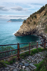 Ligurian coast. Cinque Terre National Park. Stone path to the sea. View of the stone sea coast of Italy. The road to the beach of Corniglia.