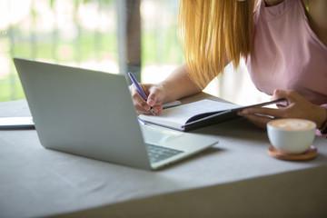 Businesswoman sitting at desk and working with laptop computer.