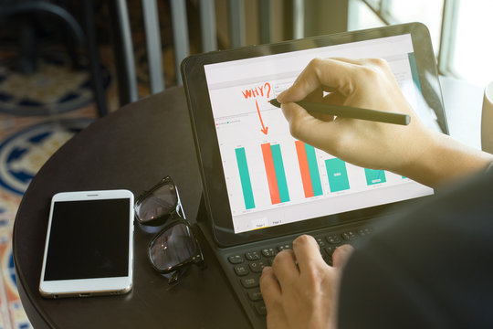 businessman using drawing comment in tablet for analysis graph visualization at coffee shop