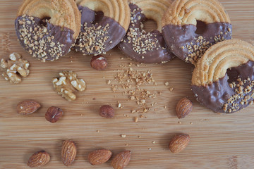  Aerial photo of chocolate covered cookies and almond chips on a wooden board.