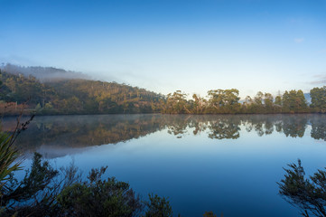 Beautiful landscape with mirror like water surface reflecting trees and sky