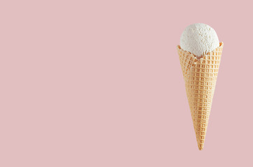 White creamy ice cream in crisp waffle cone on soft light pastel pink background, mock up, copy space.