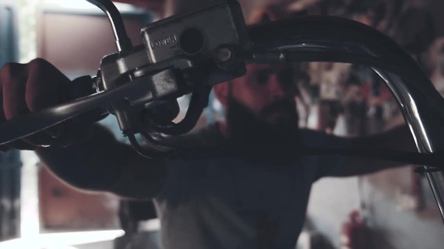 biker with a motorcycle in an atmospheric garage. a man sits on his iron horse and prepares to set off