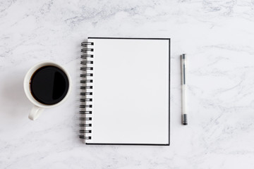 Notepad on desk with coffee and pen