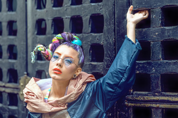 Portrait of hipster street fashion young woman with cool hairstyle and trendy funky glasses