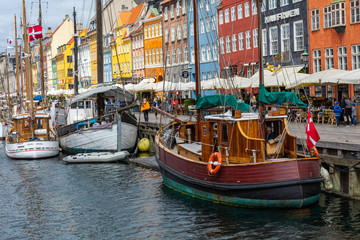 Scenic summer view of Nyhavn pier with color buildings, ships, yachts and other boats in the Old Town of Copenhagen, Denmark.
