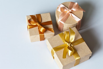 Three gift boxes tied with delicate satin ribbons with presents for a family holiday