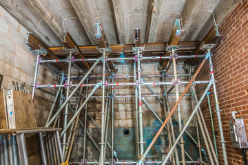 scaffolding supporting masonry wall about to collapse