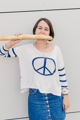 Young caucasian woman eats french baguette