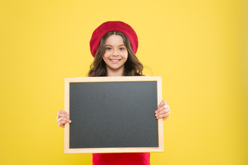 little girl kid with backboard, copy space. board for announcement advertisement. back to school. school shopping sales. kid fashion. happy school girl in parisian beret. We can Serve you better