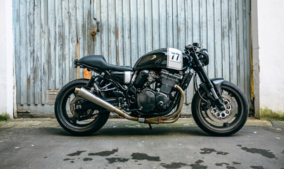 Fototapeta na wymiar Shiny customized motorcycle parked in front of garage door