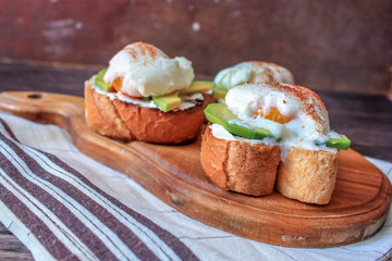 poached egg with avocado on a wooden Board