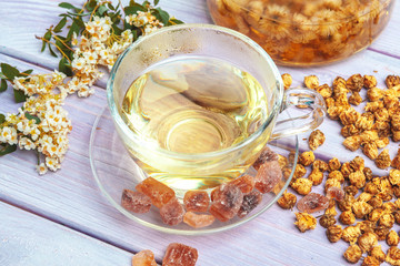 Kettle of herbal tea close up on wooden table top view