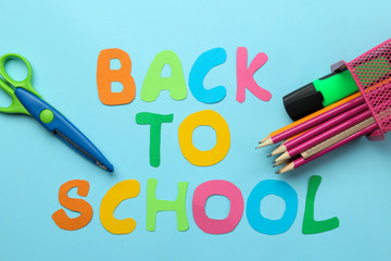 Color pencils and text back to school on a bright blue paper background. Office tools. education. . top view.