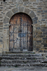 Fototapeta na wymiar puerta de madera maciza en una pared de piedra