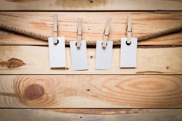 Notes and a clothes pegs on wooden background